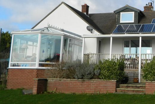 White uPVC victorian conservatory with a veranda